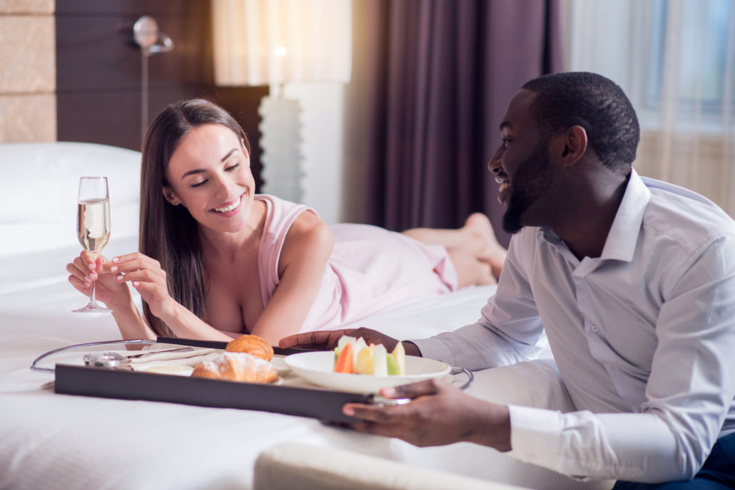 Couple getting room service with champagne in hotel room