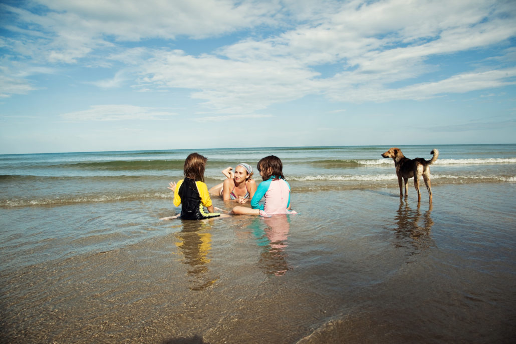 family on beach during vacation with dog