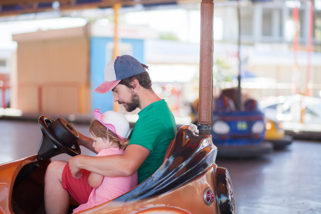 father and child playing at theme park