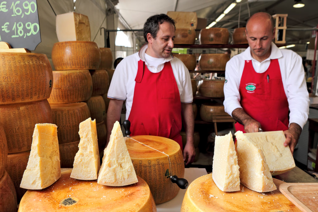 Cheesemakers and wheels of Parmesan in Italy