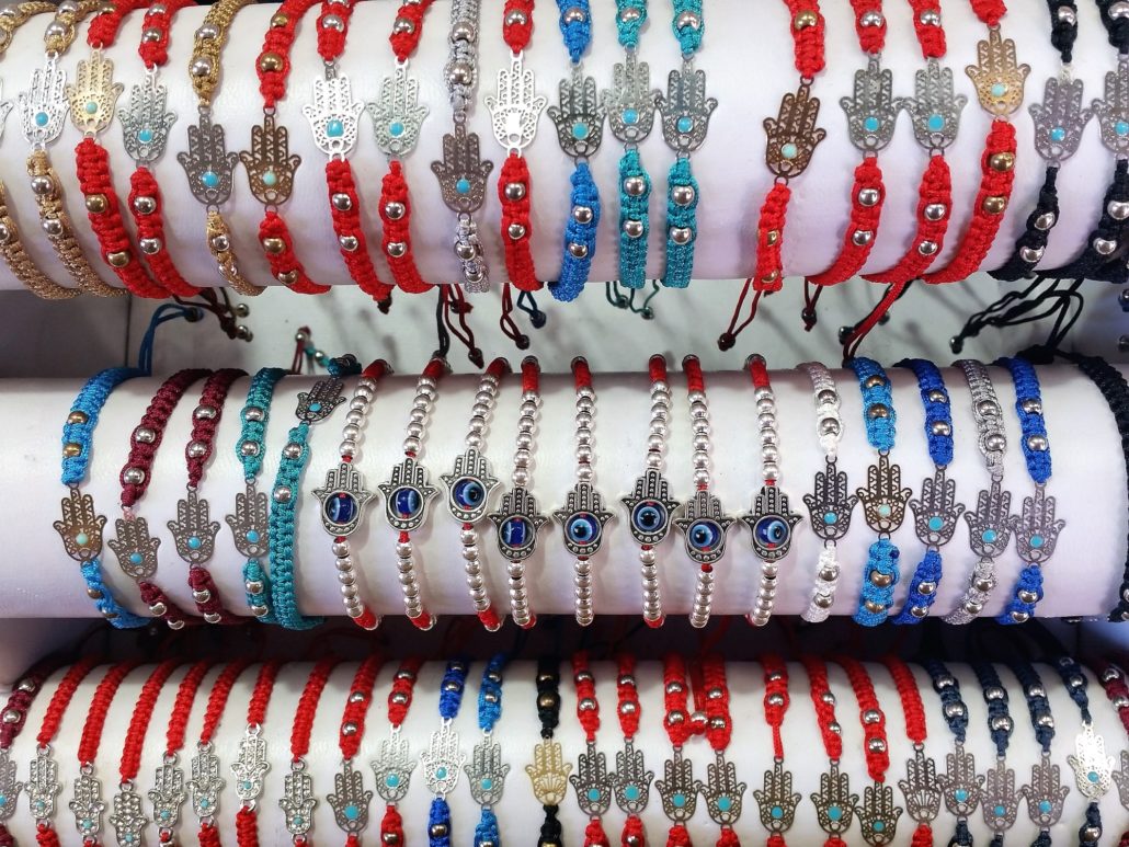 Arabic Bracelets With Lucky Talisman Symbols Like Hamsa Hand And Blue Eye In A Market Stand